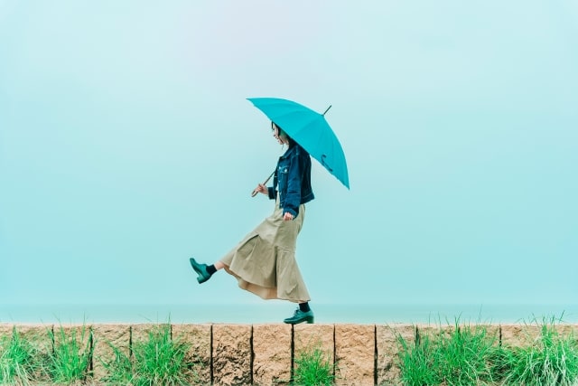 雨の中傘を差して歩く女性